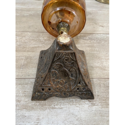 177 - Three oil lamps, two vintage brass and one Victorian cast iron with orange glass reservoir