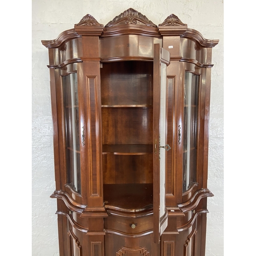 179 - An Italian style inlaid mahogany bow fronted display cabinet with three lower cupboard doors, three ... 