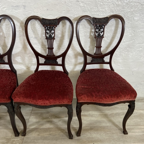 200 - A set of four Edwardian mahogany dining chairs with carved detailed backs and cabriole supports