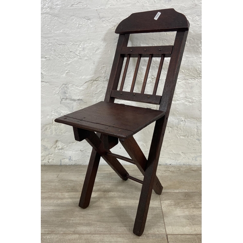 25 - A late 19th/early 20th century oak folding child's chair - approx. 66cm high