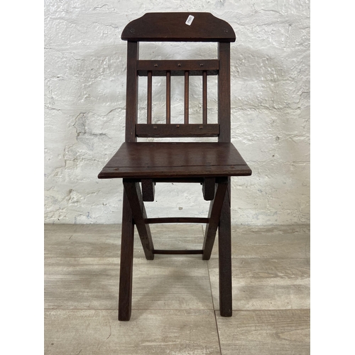 25 - A late 19th/early 20th century oak folding child's chair - approx. 66cm high