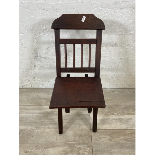 25 - A late 19th/early 20th century oak folding child's chair - approx. 66cm high