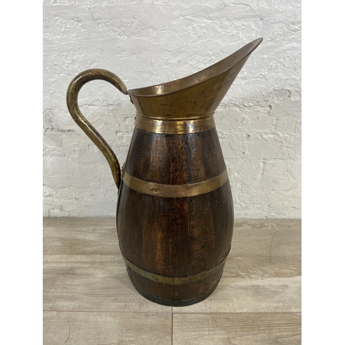 27 - An early 20th century coopered oak and brass jug - approx. 60cm high