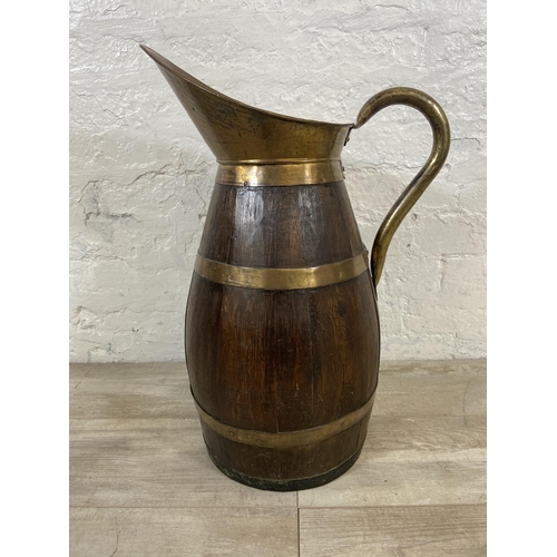 27 - An early 20th century coopered oak and brass jug - approx. 60cm high