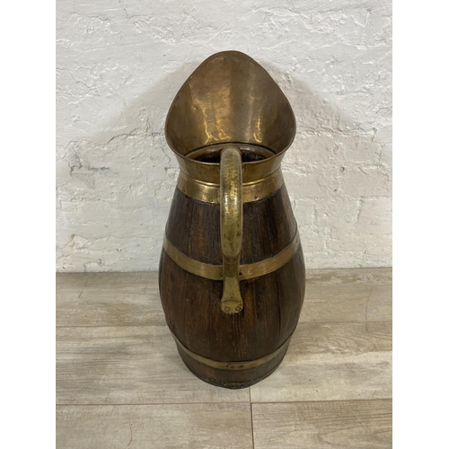 27 - An early 20th century coopered oak and brass jug - approx. 60cm high