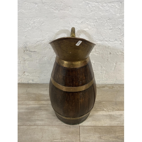 27 - An early 20th century coopered oak and brass jug - approx. 60cm high