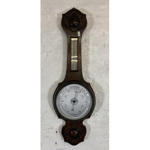 30 - An early 20th century carved oak cased British made aneroid barometer - approx. 79cm high