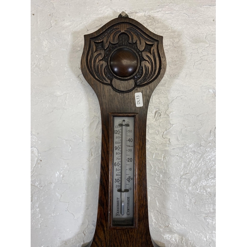 30 - An early 20th century carved oak cased British made aneroid barometer - approx. 79cm high