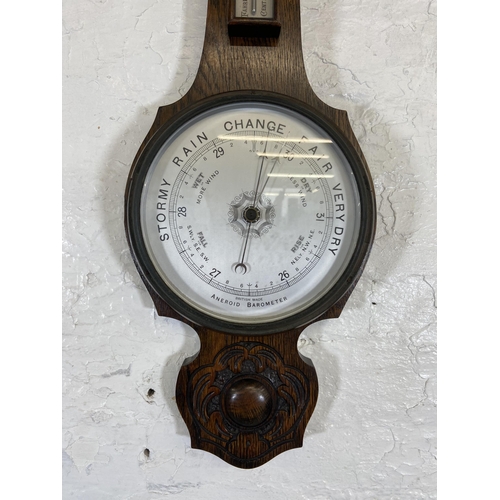 30 - An early 20th century carved oak cased British made aneroid barometer - approx. 79cm high