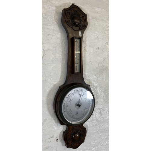 30 - An early 20th century carved oak cased British made aneroid barometer - approx. 79cm high