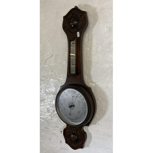 30 - An early 20th century carved oak cased British made aneroid barometer - approx. 79cm high