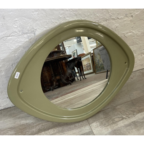 56 - A mid 20th century green glazed ceramic framed wall mirror - approx. 50cm high x 63cm wide