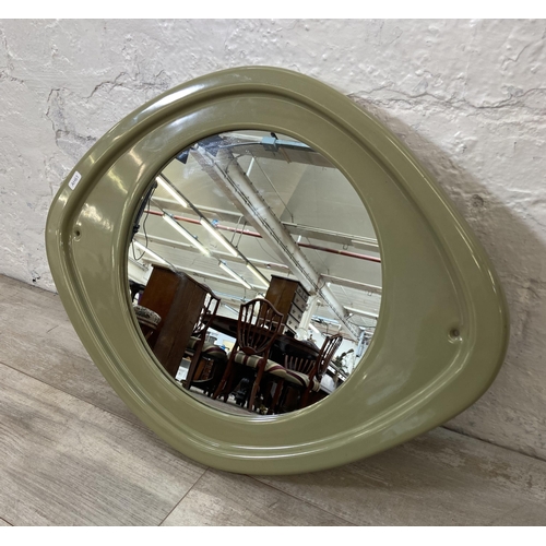 56 - A mid 20th century green glazed ceramic framed wall mirror - approx. 50cm high x 63cm wide