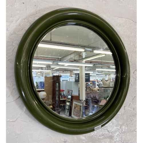 57 - A mid 20th century green plastic framed circular wall mirror - approx. 40cm diameter