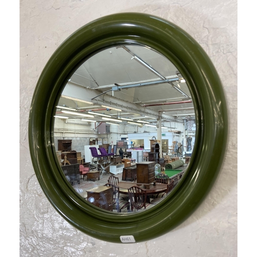 57 - A mid 20th century green plastic framed circular wall mirror - approx. 40cm diameter