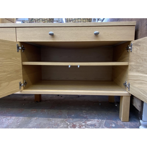 115 - A modern light oak sideboard with four cupboard doors and two drawers - approx. 67cm high x 156cm lo... 