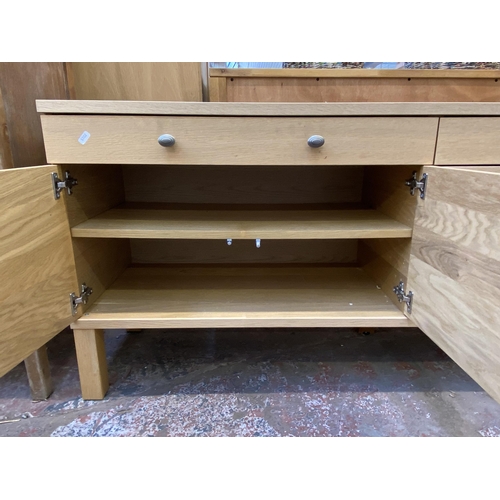 115 - A modern light oak sideboard with four cupboard doors and two drawers - approx. 67cm high x 156cm lo... 