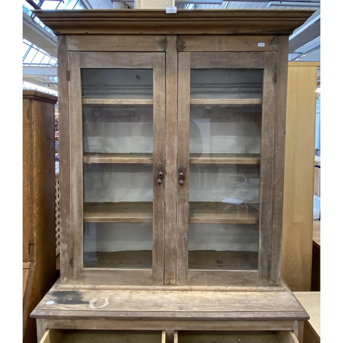 116 - A late 19th century pine bookcase with two long drawers, two short drawers, two glazed doors and thr... 