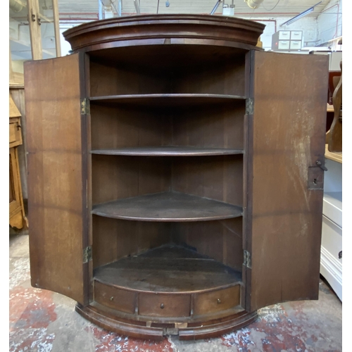 118 - A Georgian flamed mahogany bow fronted wall hanging corner cabinet - approx. 100cm high x 67cm wide ... 