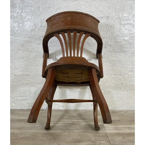 121 - An early 20th century oak desk chair on cabriole supports with lower stretchers and upholstered seat... 