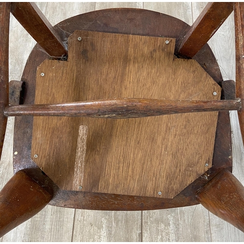 122 - An early 20th century oak desk chair on cabriole supports with lower stretchers and upholstered seat... 