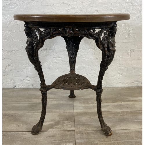 127 - A Victorian cast iron Britannia pub table with later added circular oak top - approx. 76cm high x 67... 