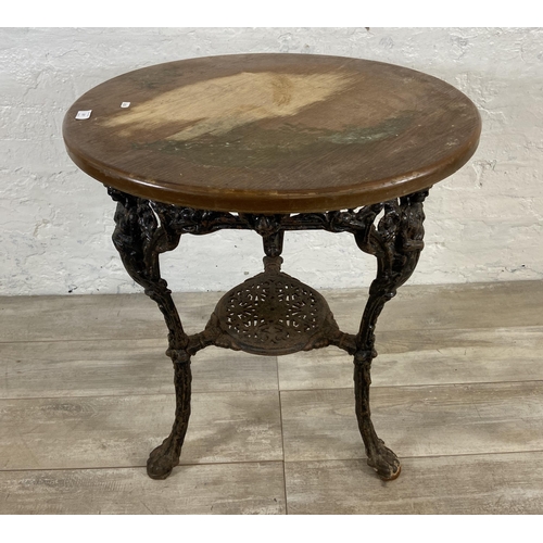 127 - A Victorian cast iron Britannia pub table with later added circular oak top - approx. 76cm high x 67... 