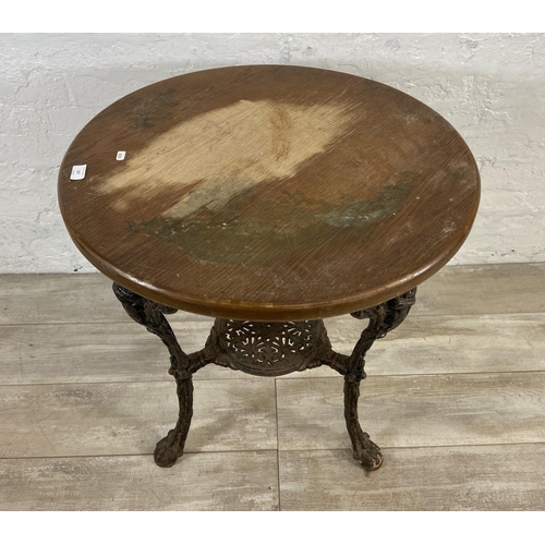 127 - A Victorian cast iron Britannia pub table with later added circular oak top - approx. 76cm high x 67... 