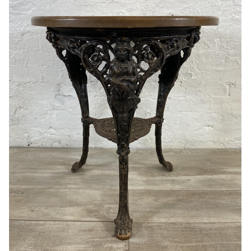 127 - A Victorian cast iron Britannia pub table with later added circular oak top - approx. 76cm high x 67... 