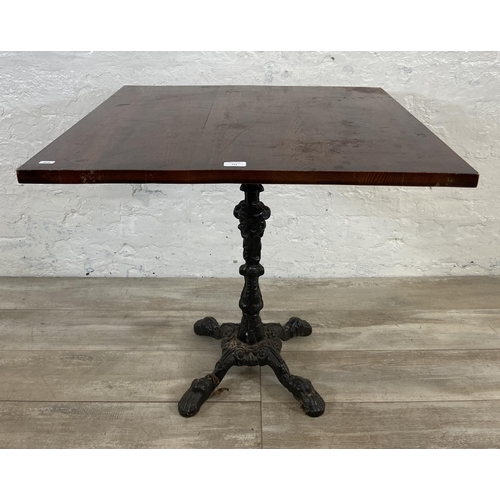 131 - A Victorian style cast iron pedestal bistro/pub table with later added oak top - approx. 70.5cm high... 