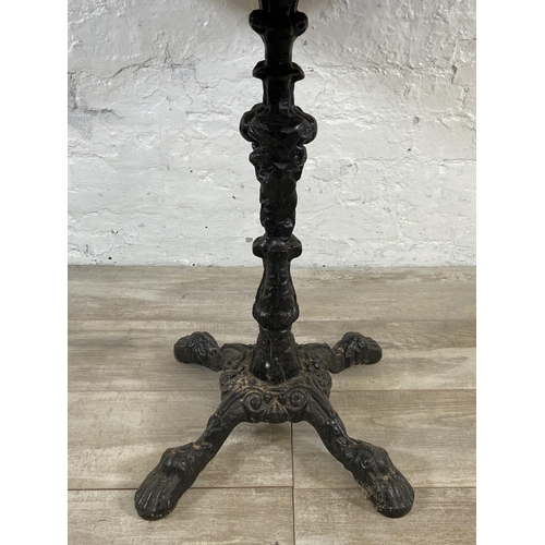 131 - A Victorian style cast iron pedestal bistro/pub table with later added oak top - approx. 70.5cm high... 