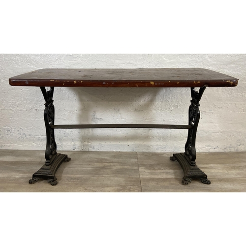 134A - A Coalbrookdale style cast iron twin pedestal garden table with later added stained pine top - appro... 