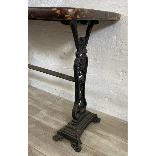 134A - A Coalbrookdale style cast iron twin pedestal garden table with later added stained pine top - appro... 