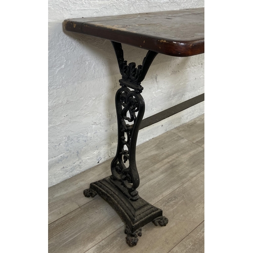 134A - A Coalbrookdale style cast iron twin pedestal garden table with later added stained pine top - appro... 