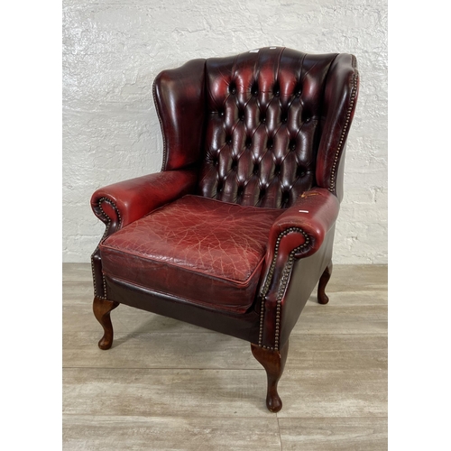 146 - An oxblood leather Chesterfield wingback armchair