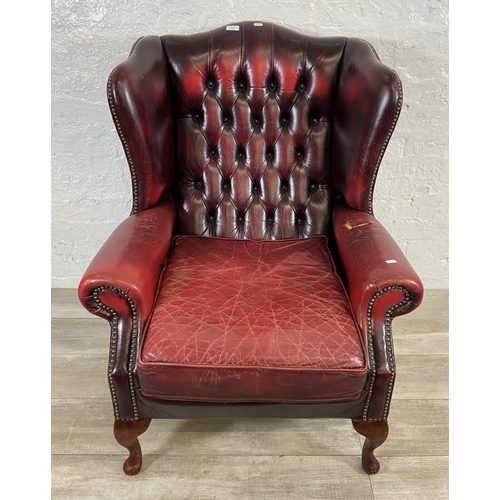 146 - An oxblood leather Chesterfield wingback armchair