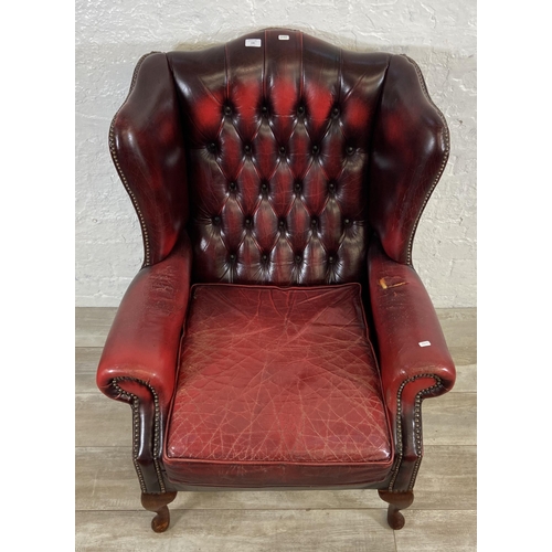 146 - An oxblood leather Chesterfield wingback armchair