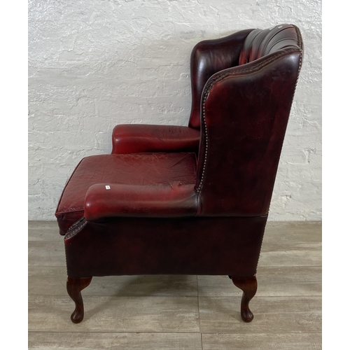 146 - An oxblood leather Chesterfield wingback armchair