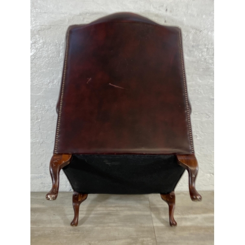 146 - An oxblood leather Chesterfield wingback armchair