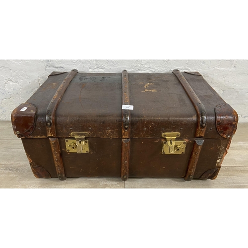 153 - An early/mid 20th century brown canvas and wooden banded travel trunk