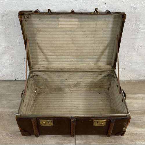 153 - An early/mid 20th century brown canvas and wooden banded travel trunk