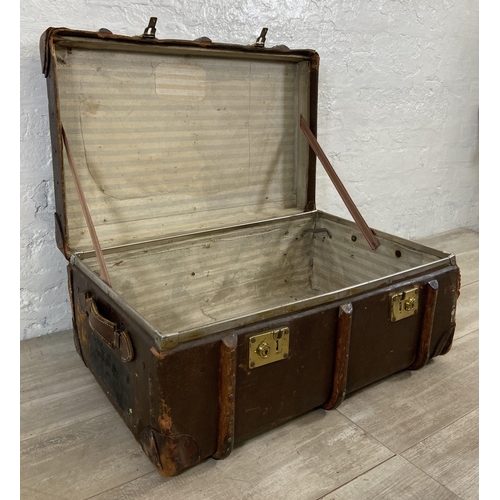 153 - An early/mid 20th century brown canvas and wooden banded travel trunk