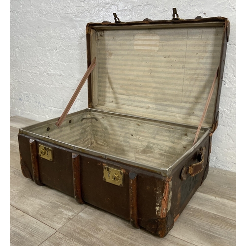 153 - An early/mid 20th century brown canvas and wooden banded travel trunk