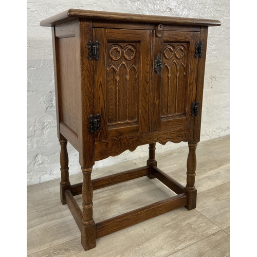 170 - A carved oak two door cabinet - approx. 68cm high x 50.5cm wide x 33cm deep