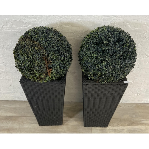 172 - Four items, a pair of black plastic rattan effect garden planters and a pair of artificial buxus pla... 