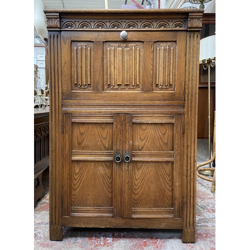 47 - A carved oak linenfold drinks cabinet with fitted interior - approx. 122cm high x 80cm wide x 48cm d... 