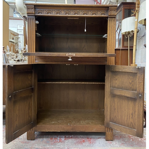 47 - A carved oak linenfold drinks cabinet with fitted interior - approx. 122cm high x 80cm wide x 48cm d... 