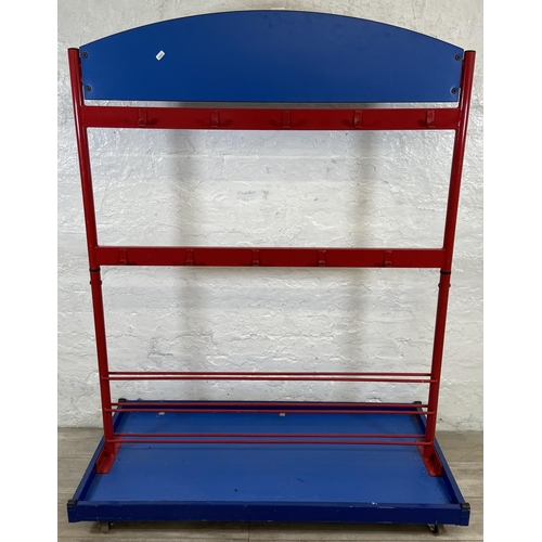 52 - A red metal and blue plastic child's coat rack on castors - approx. 154cm high x 120cm wide x 60cm d... 