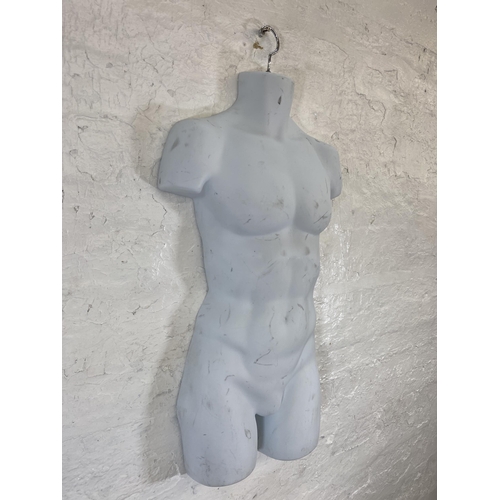 55 - Two mannequins, one plastic hanging male torso and one polystyrene female torso on tripod stand