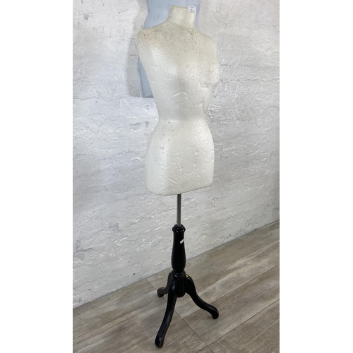 55 - Two mannequins, one plastic hanging male torso and one polystyrene female torso on tripod stand